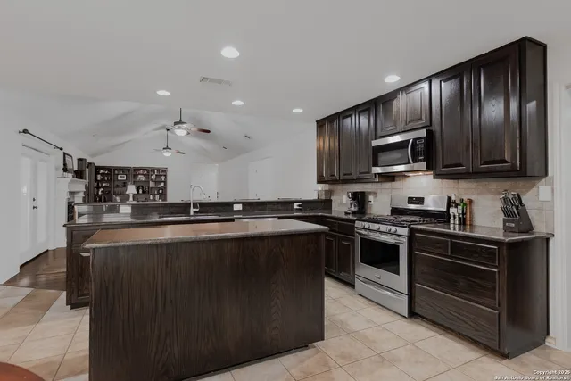 a kitchen with stainless steel appliances granite countertop a stove sink microwave and cabinets