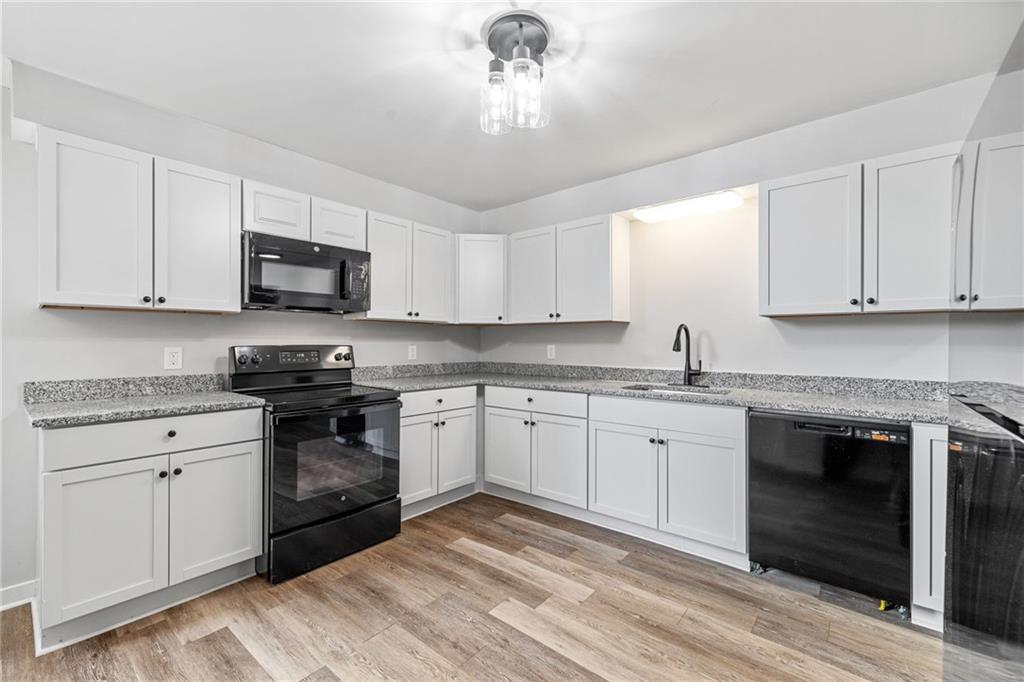 1319 Adams Street Pittsburgh, PA 15233 - Photo 13 of 27 a kitchen with granite countertop a sink stainless steel appliances and white cabinets