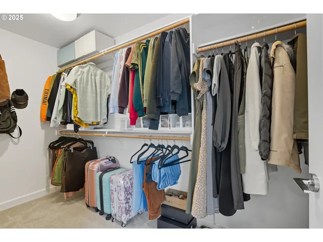 a view of walk in closet with clothes and shoes