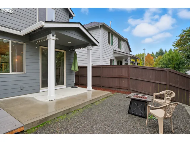 a backyard of a house with table and chairs