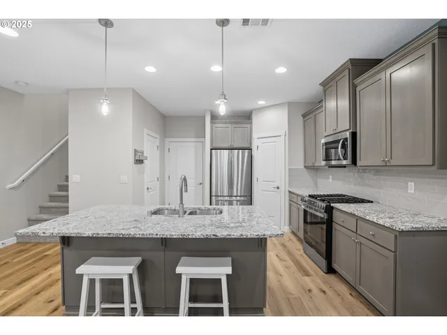 a kitchen with kitchen island granite countertop stainless steel appliances and wooden cabinets