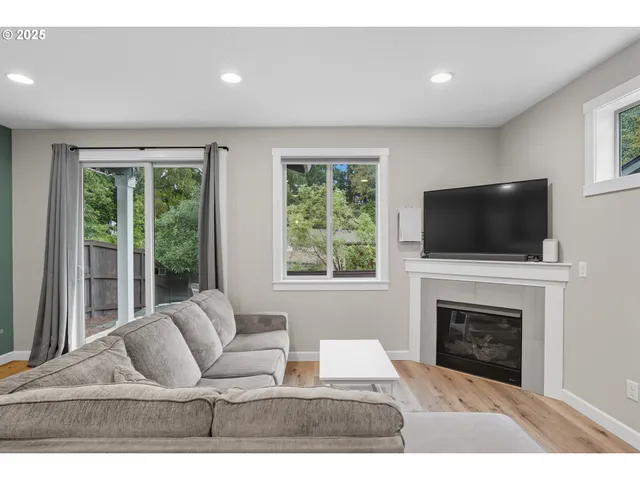 a living room with furniture a flat screen tv and a fireplace