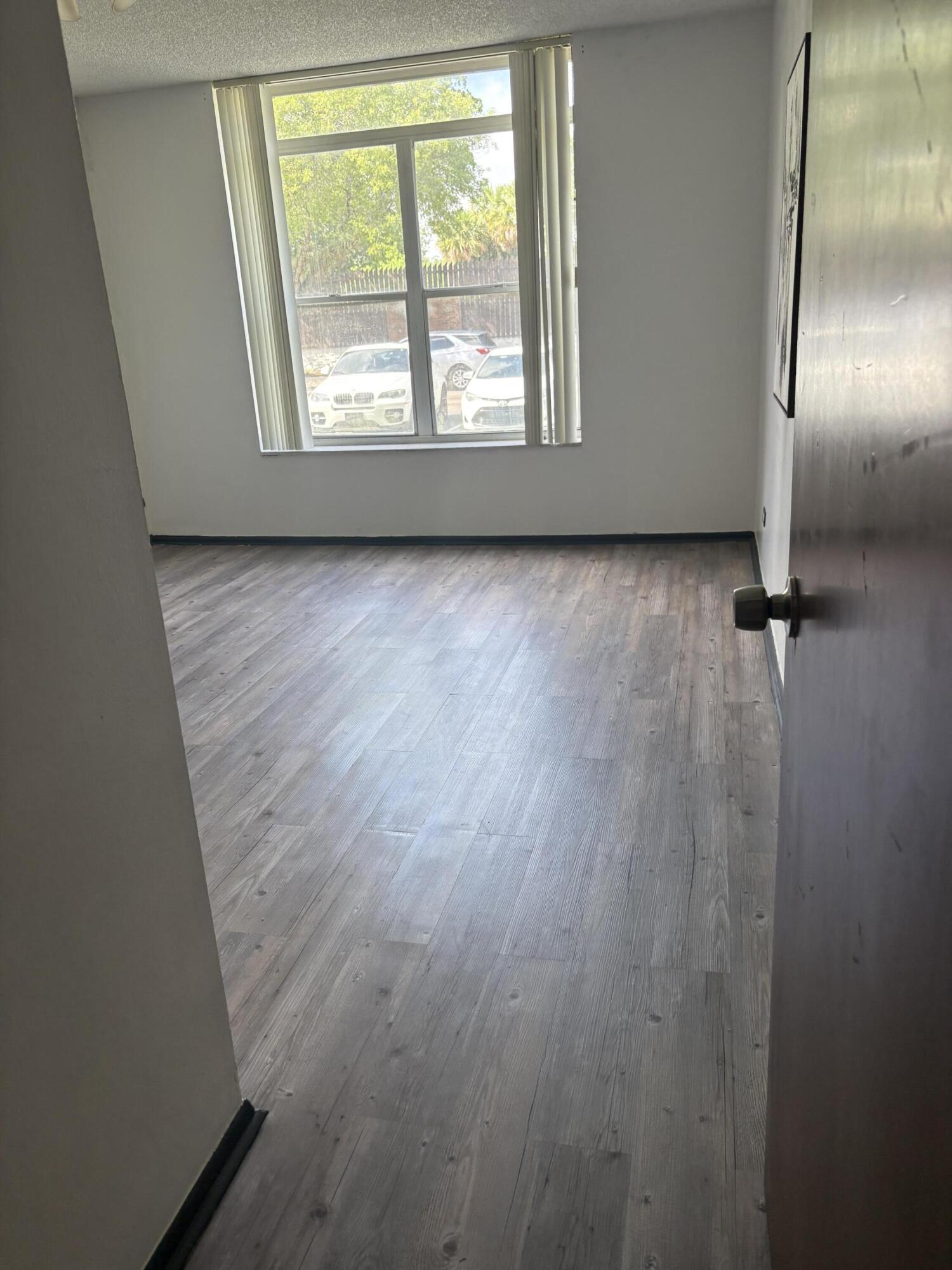 3660 Inverrary Drive, Unit 1B Lauderhill, FL 33319 - Photo 26 of 27 wooden floor in an empty room with a window