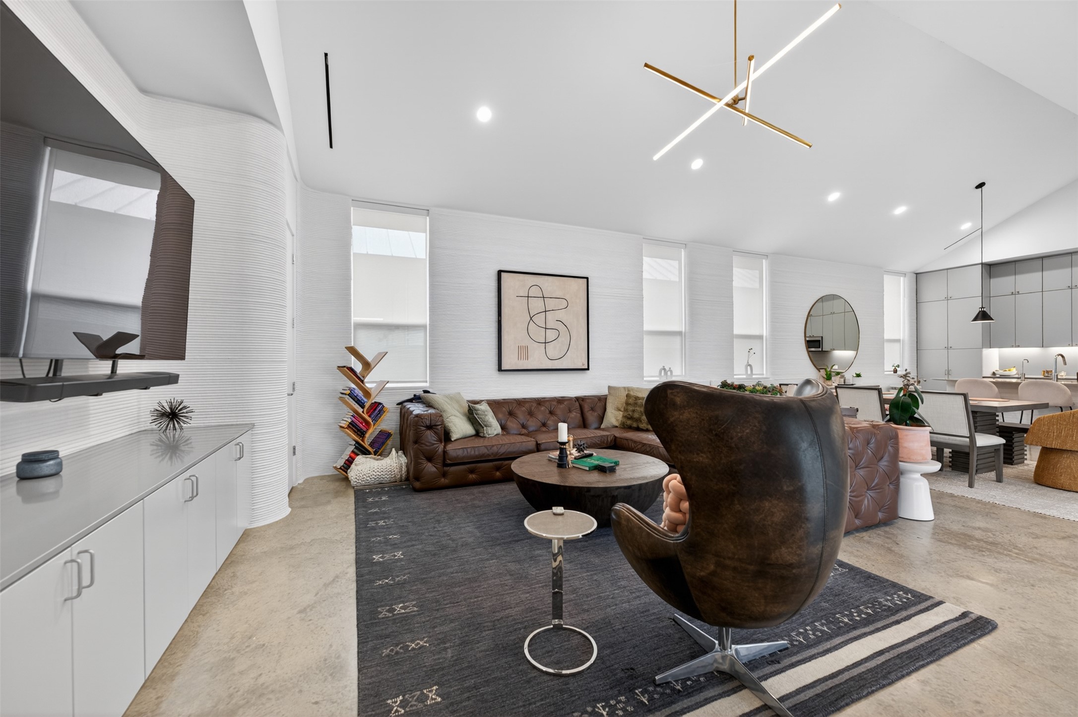 308 Painted Sunset Drive Georgetown, TX 78628 - Photo 4 of 26 Open-concept living space featuring concrete flooring, textured walls, recessed lighting, and a contemporary linear chandelier