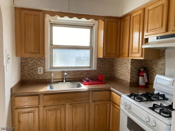 a kitchen with granite countertop a sink stove and cabinets