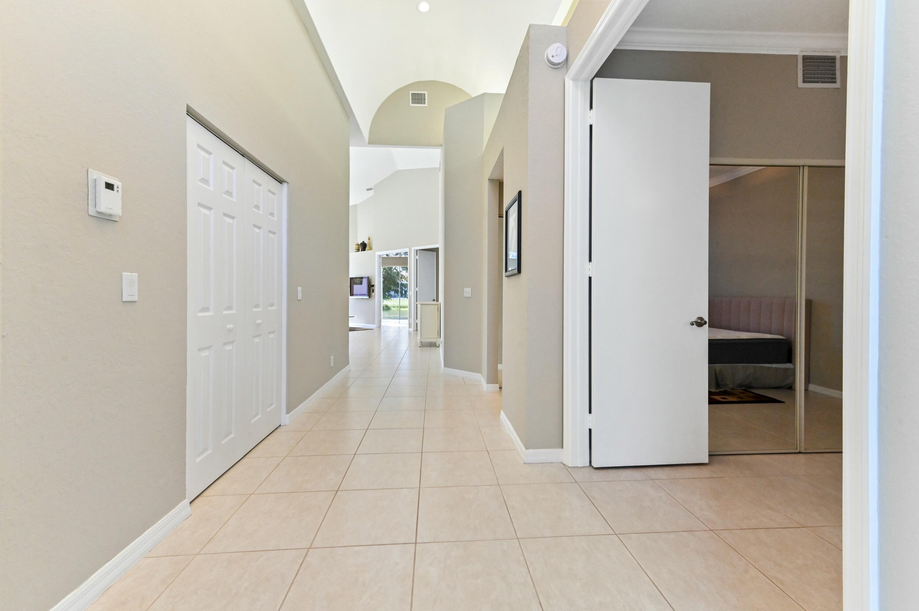 17272 Hampton Boulevard Boca Raton, FL 33496 - Photo 12 of 33 a view of a hallway with a wooden shelves