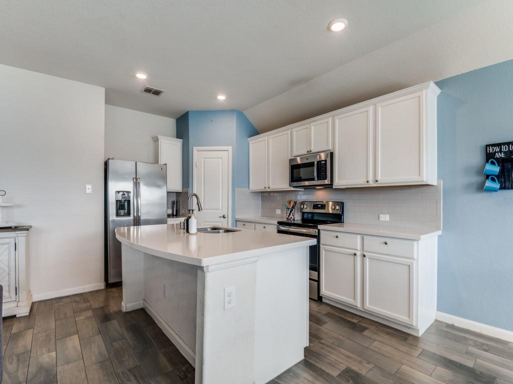 115 Garner Court Forney, TX 75126 - Photo 9 of 26 a kitchen with stainless steel appliances granite countertop a sink stove microwave and refrigerator