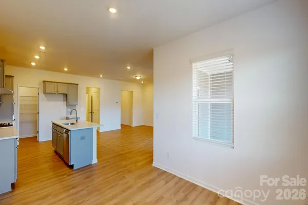 a view of kitchen and kitchen with furniture wooden floor and windows