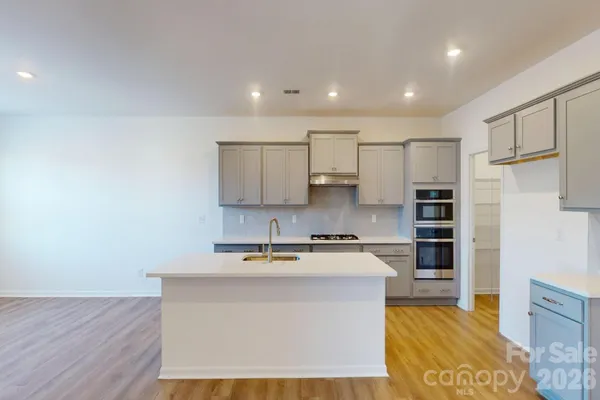 a kitchen with kitchen island a sink stainless steel appliances and cabinets