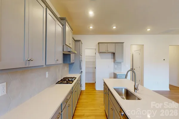 a kitchen with stainless steel appliances granite countertop a sink a stove and a refrigerator