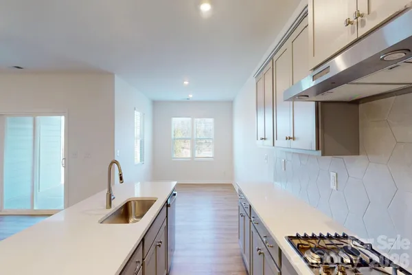 a kitchen with granite countertop a sink a stove and cabinets