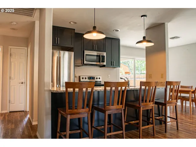 a kitchen with stainless steel appliances granite countertop a sink stove and microwave