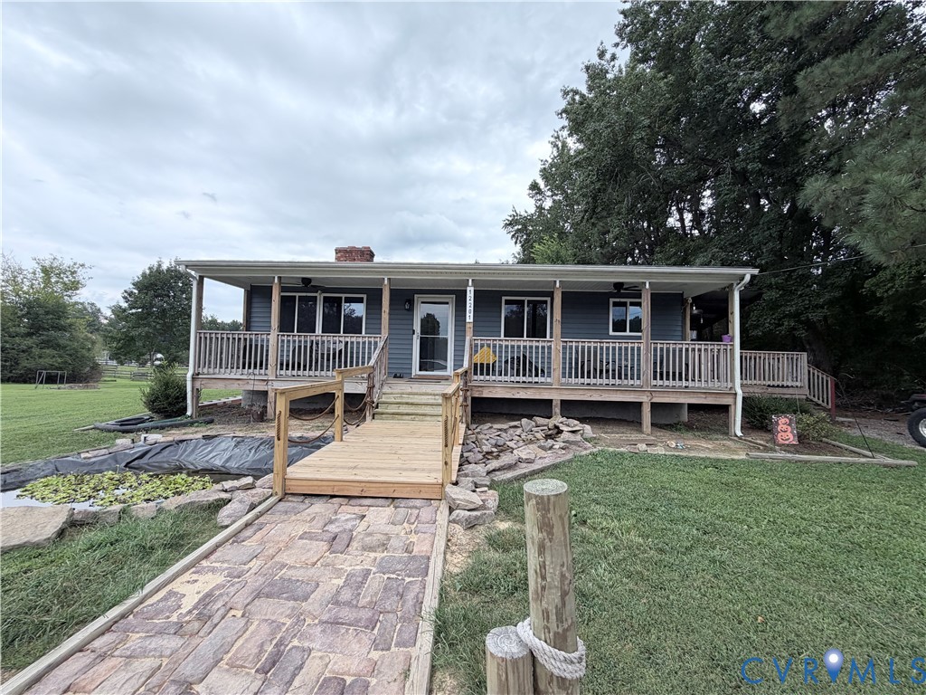 Exterior featuring a covered porch, wood deck, and