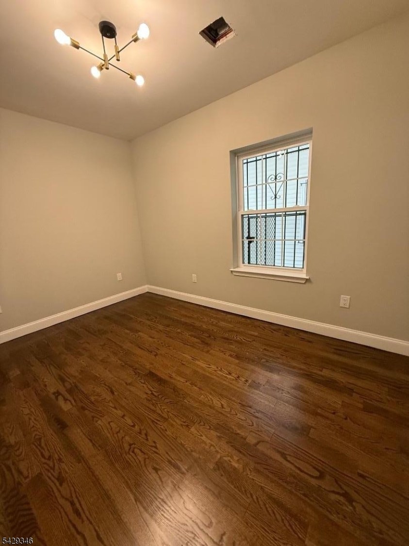 223 South 11th Street Newark, NJ 07107 - Photo 6 of 11 an empty room with wooden floor and windows