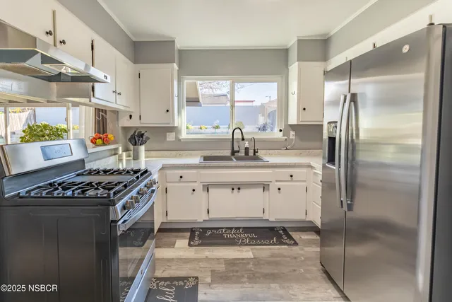 a kitchen with stainless steel appliances granite countertop a sink stove and refrigerator