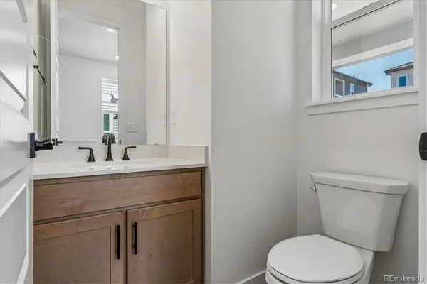 a bathroom with a sink a toilet a mirror and vanity