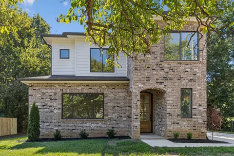 front view of a stone house with a yard