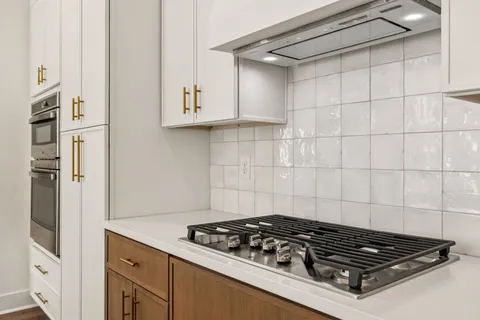 a stove top oven sitting inside of a kitchen