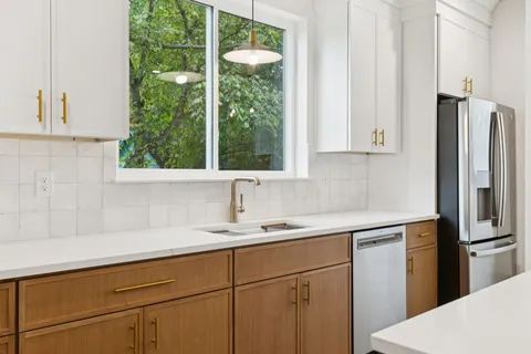 a kitchen with a sink a refrigerator and window