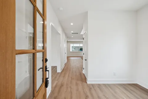 a view of a hallway with wooden floor and staircase
