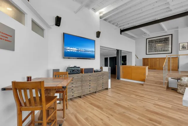 a living room with furniture flat screen tv and chairs