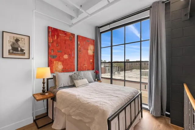 a bed sitting in a bedroom next to a window