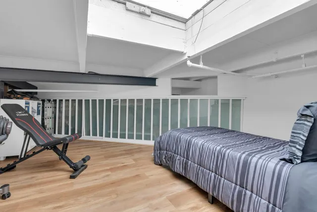 a bed sitting in a spacious bedroom next to a window