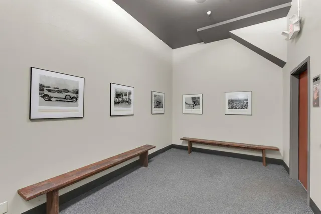 a view of a hallway with wooden floor and a refrigerator
