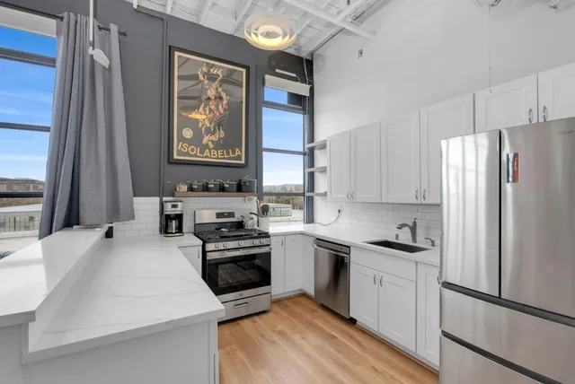 a kitchen with cabinets stainless steel appliances and a window