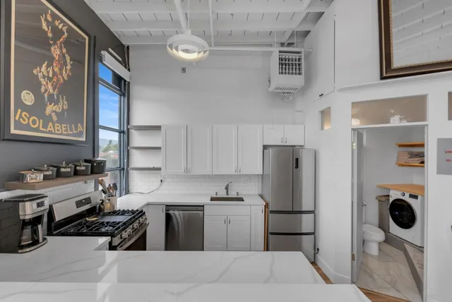 a kitchen with stainless steel appliances granite countertop a refrigerator sink and stove