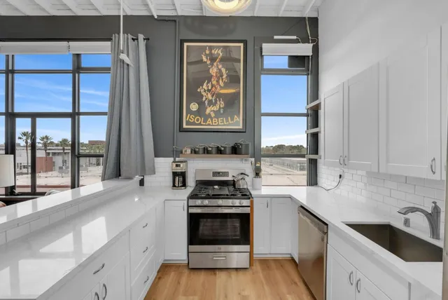 a kitchen with stainless steel appliances a stove sink and cabinets