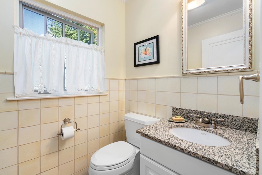 35 Shaw Road Brookline, MA 02467 - Photo 20 of 40 a bathroom with a granite countertop sink a toilet and mirror