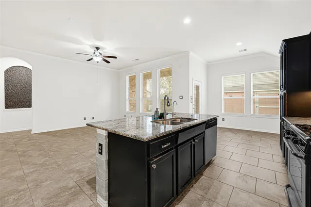 a kitchen with granite countertop a sink appliances and cabinets