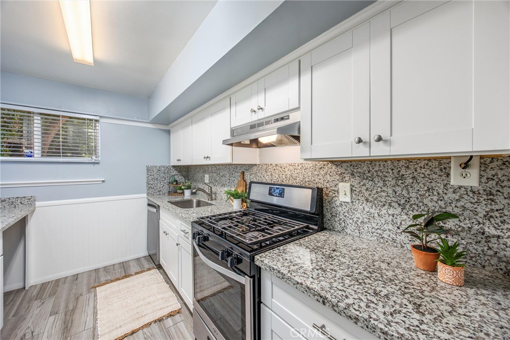 135 North Center Street Redlands, CA 92373 - Photo 13 of 36 a kitchen with a stove and white cabinets