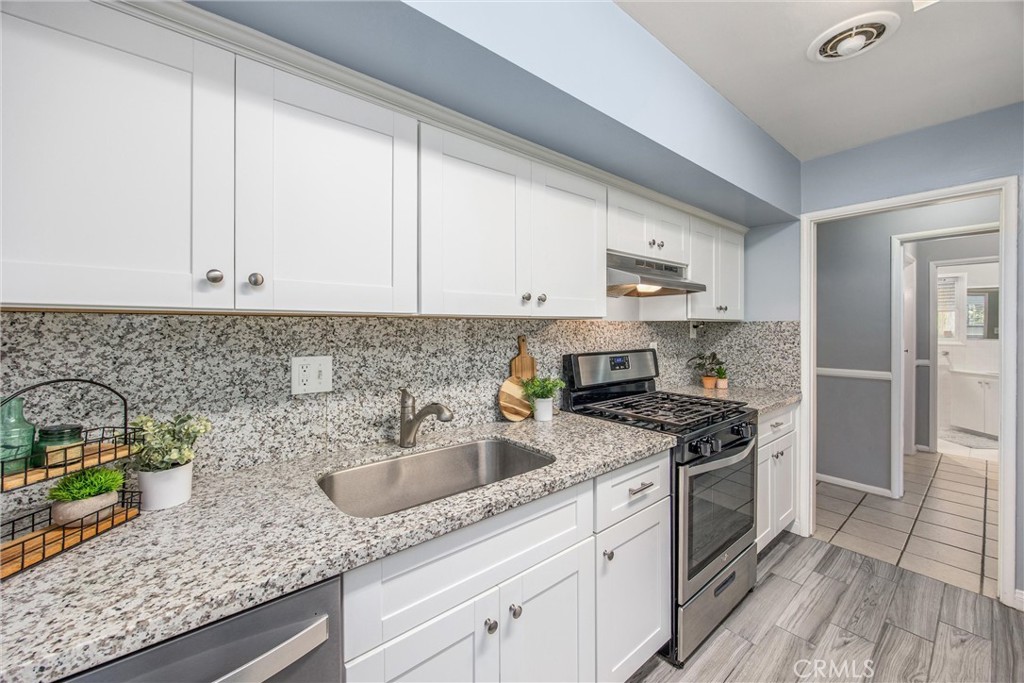 135 North Center Street Redlands, CA 92373 - Photo 15 of 36 a kitchen with stainless steel appliances granite countertop a sink stove and cabinets