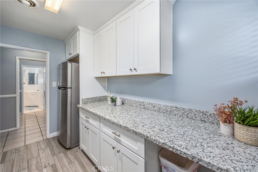 135 North Center Street Redlands, CA 92373 - Photo 16 of 36 a kitchen with granite countertop a refrigerator and wooden floor