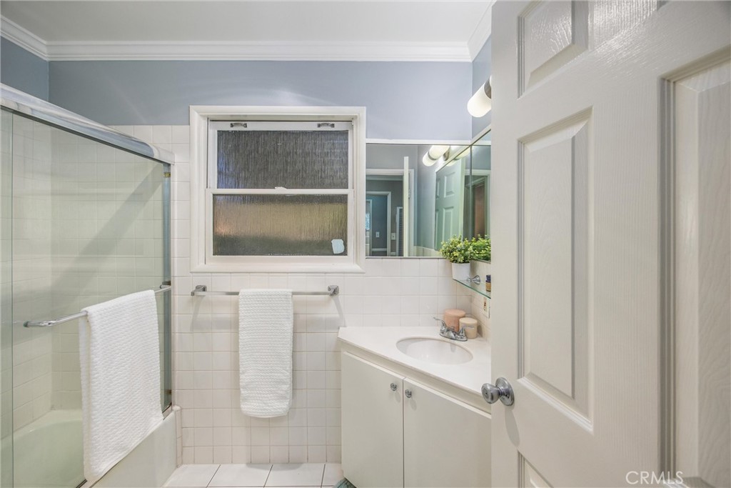 135 North Center Street Redlands, CA 92373 - Photo 21 of 36 a bathroom with a granite countertop sink a mirror and shower