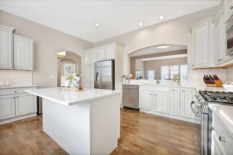 a kitchen with white cabinets appliances and sink