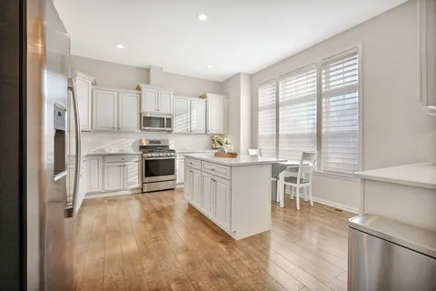 a kitchen with white cabinets and white appliances