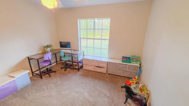 a view of a workspace with furniture and a window