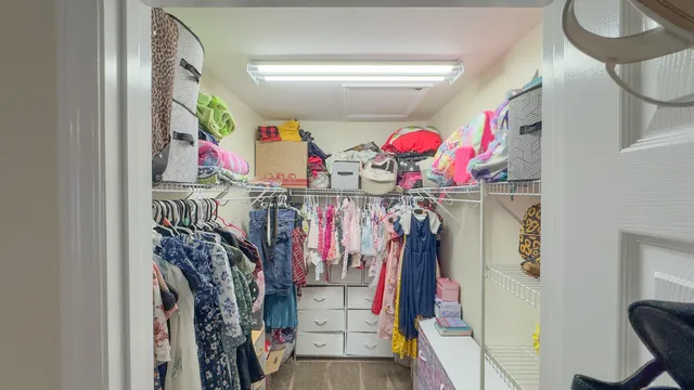 a view of walk in closet with clothes