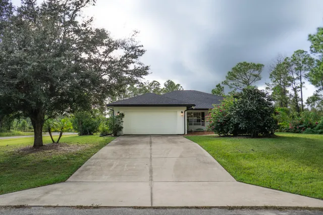 a front view of a house with a yard and trees