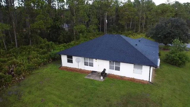 a white house with tall trees