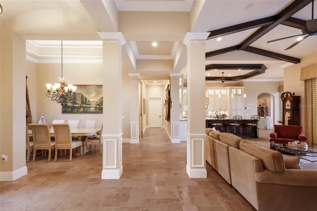 a living room with furniture a ceiling fan and a large window