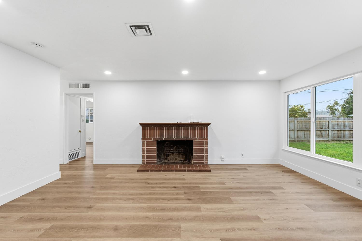 3473 East Dayton Avenue Fresno, CA 93726 - Photo 13 of 49 a view of an empty room with wooden floor and a window