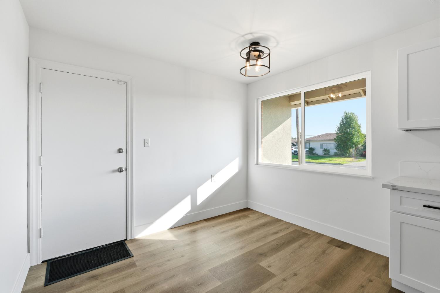 3473 East Dayton Avenue Fresno, CA 93726 - Photo 14 of 49 a view of an empty room with wooden floor and a window