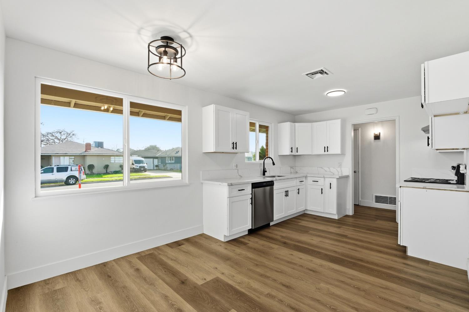 3473 East Dayton Avenue Fresno, CA 93726 - Photo 15 of 49 a kitchen with a refrigerator a stove a sink and a large window