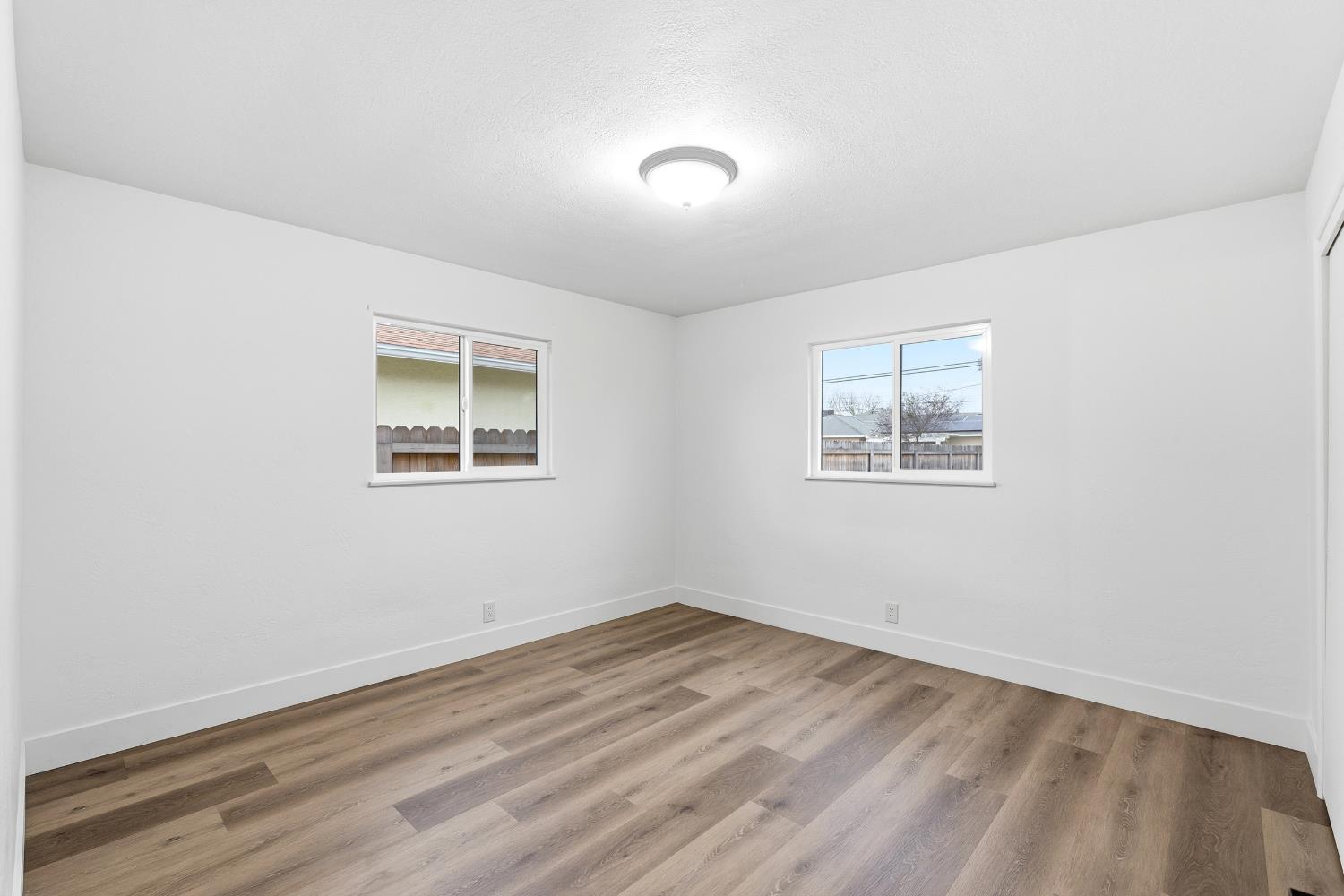 3473 East Dayton Avenue Fresno, CA 93726 - Photo 29 of 49 a view of empty room with wooden floor and fan