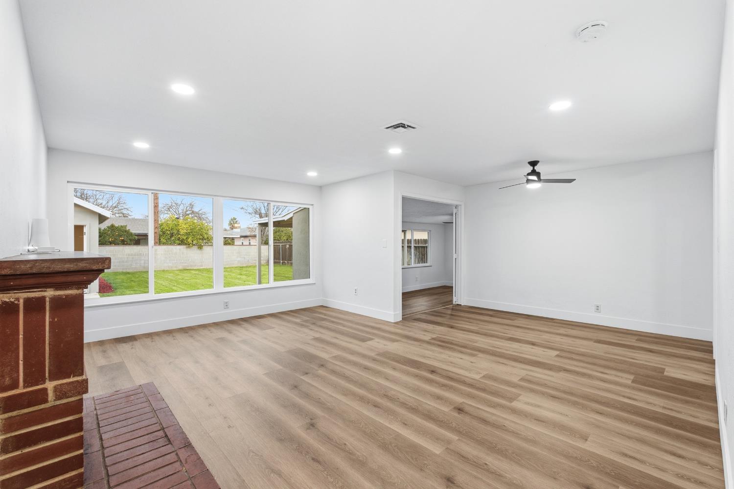 3473 East Dayton Avenue Fresno, CA 93726 - Photo 3 of 49 an empty room with wooden floor and windows