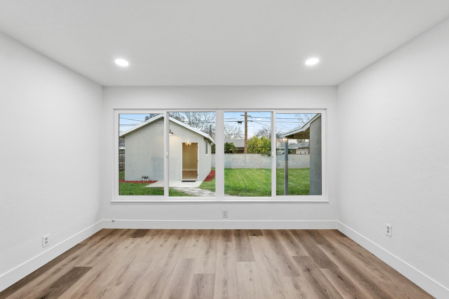 3473 East Dayton Avenue Fresno, CA 93726 - Photo 8 of 49 an empty room with wooden floor and a window